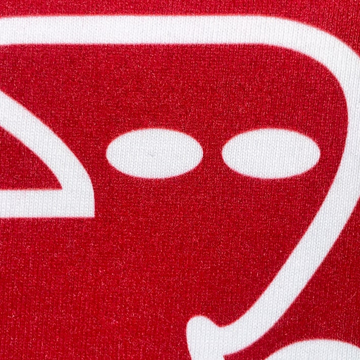 CALMECS T-SHIRT IN COLOR WHITE WITH RED AND BLUE BACK GRAPHIC PRINT. RED CALMECS LOGO CLOSE UP.