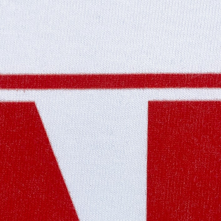 CALMECS T-SHIRT IN COLOR WHITE WITH RED AND WHITE FONT FRONT PRINT. CLOSE UP RED.