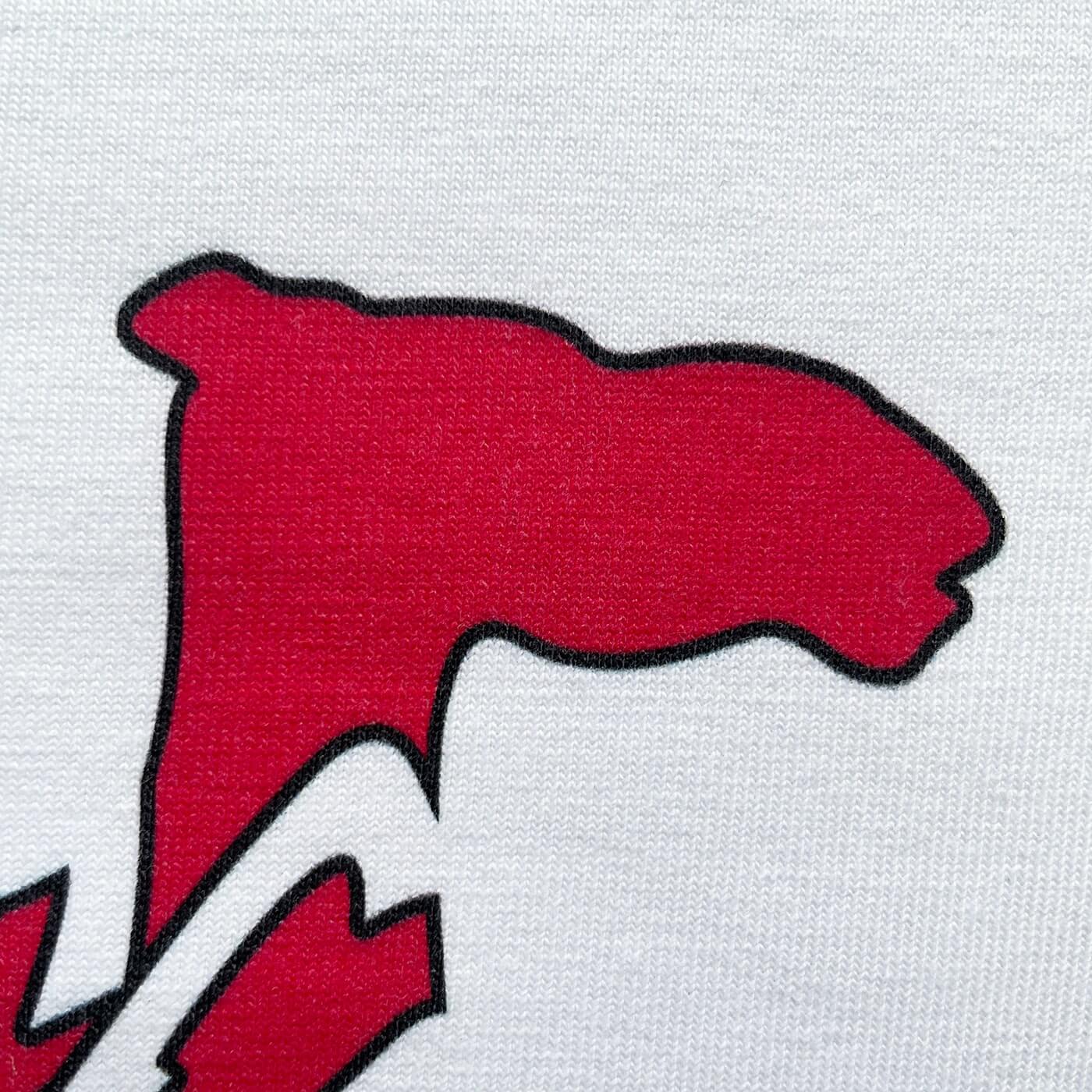 CALMECS T-SHIRT IN COLOR WHITE WITH RED AND BLUE DROMEDARY / CAMEL AND CALMECS LOGO FRONT PRINT. CLOSE UP HEAD.