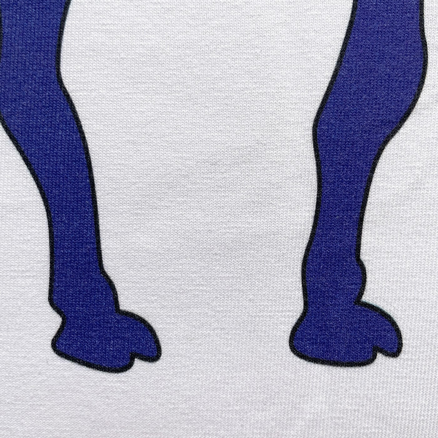 CALMECS T-SHIRT IN COLOR WHITE WITH RED AND BLUE DROMEDARY / CAMEL AND CALMECS LOGO FRONT PRINT. CLOSE UP TOE.