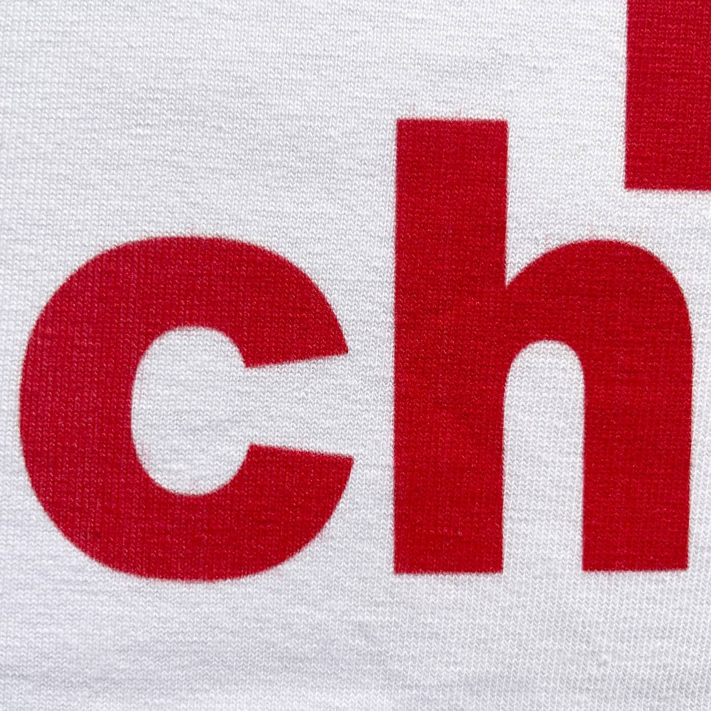 CALMECS T-SHIRT IN COLOR WHITE WITH RED MAIN CHARACTER FONT FRONT PRINT. CLOSE UP LETTERS CH.