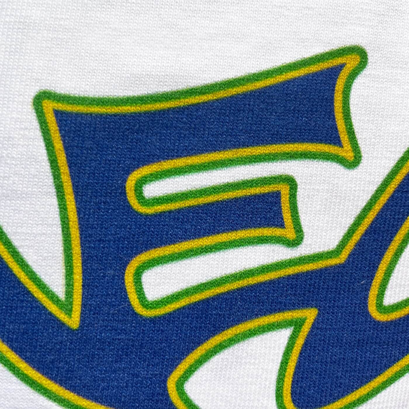 CALMECS T-SHIRT IN COLOR WHITE WITH BLUE CALMECS FONT FRONT PRINT. CLOSE UP E.