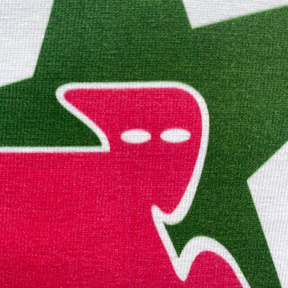 CALMECS T-SHIRT IN COLOR WHITE WITH RED AND GREEN STAR AND CALMECS LOGO FRONT PRINT. CLOSE UP LOGO.