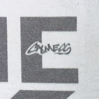 CALMECS T-SHIRT IN COLOR WHITE WITH GREY FONT FRONT PRINT. CALMECS LOGO CLOSE UP.