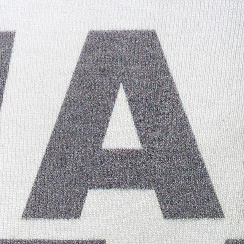 CALMECS T-SHIRT IN COLOR WHITE WITH GREY FONT FRONT PRINT. CLOSE UP FONT. 
