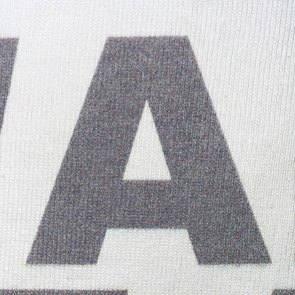CALMECS T-SHIRT IN COLOR WHITE WITH GREY FONT FRONT PRINT. CLOSE UP FONT. 