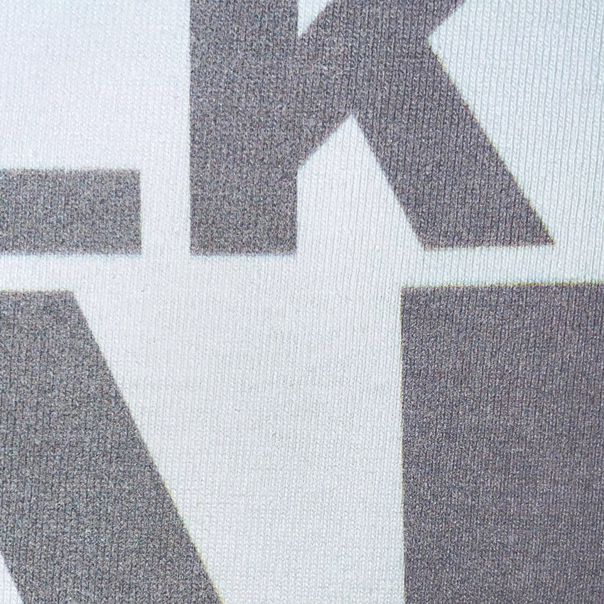 CALMECS T-SHIRT IN COLOR WHITE WITH GREY FONT FRONT PRINT. FONT CLOSE UP.