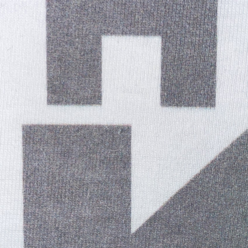 CALMECS T-SHIRT IN COLOR WHITE WITH GREY FONT FRONT PRINT.  CLOSE UP LETTER.